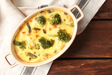 Photo of Delicious vegetable casserole on wooden table, top view