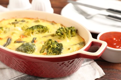 Photo of Delicious vegetable casserole and sauce on wooden table, closeup