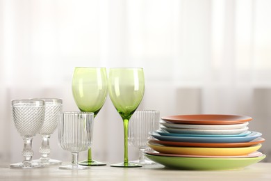 Photo of Empty clean glasses and plates on table indoors