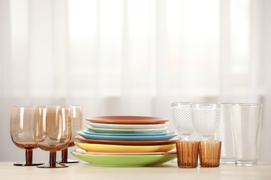 Photo of Empty clean glasses and plates on table indoors