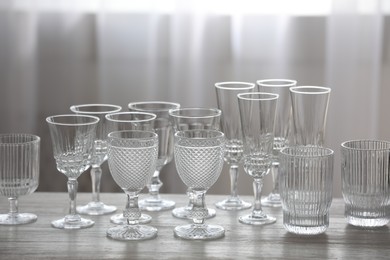 Photo of Empty clean glasses on wooden table indoors