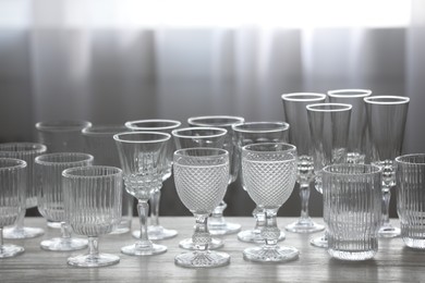 Photo of Empty clean glasses on wooden table indoors