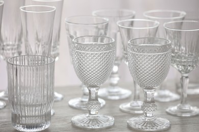 Photo of Empty clean glasses on wooden table indoors, closeup