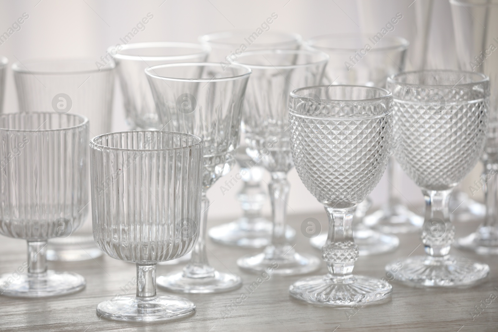 Photo of Empty clean glasses on wooden table indoors, closeup