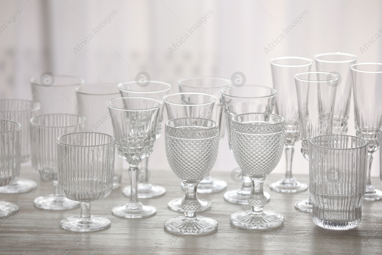 Photo of Empty clean glasses on wooden table indoors