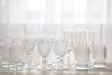 Photo of Empty clean glasses on wooden table indoors