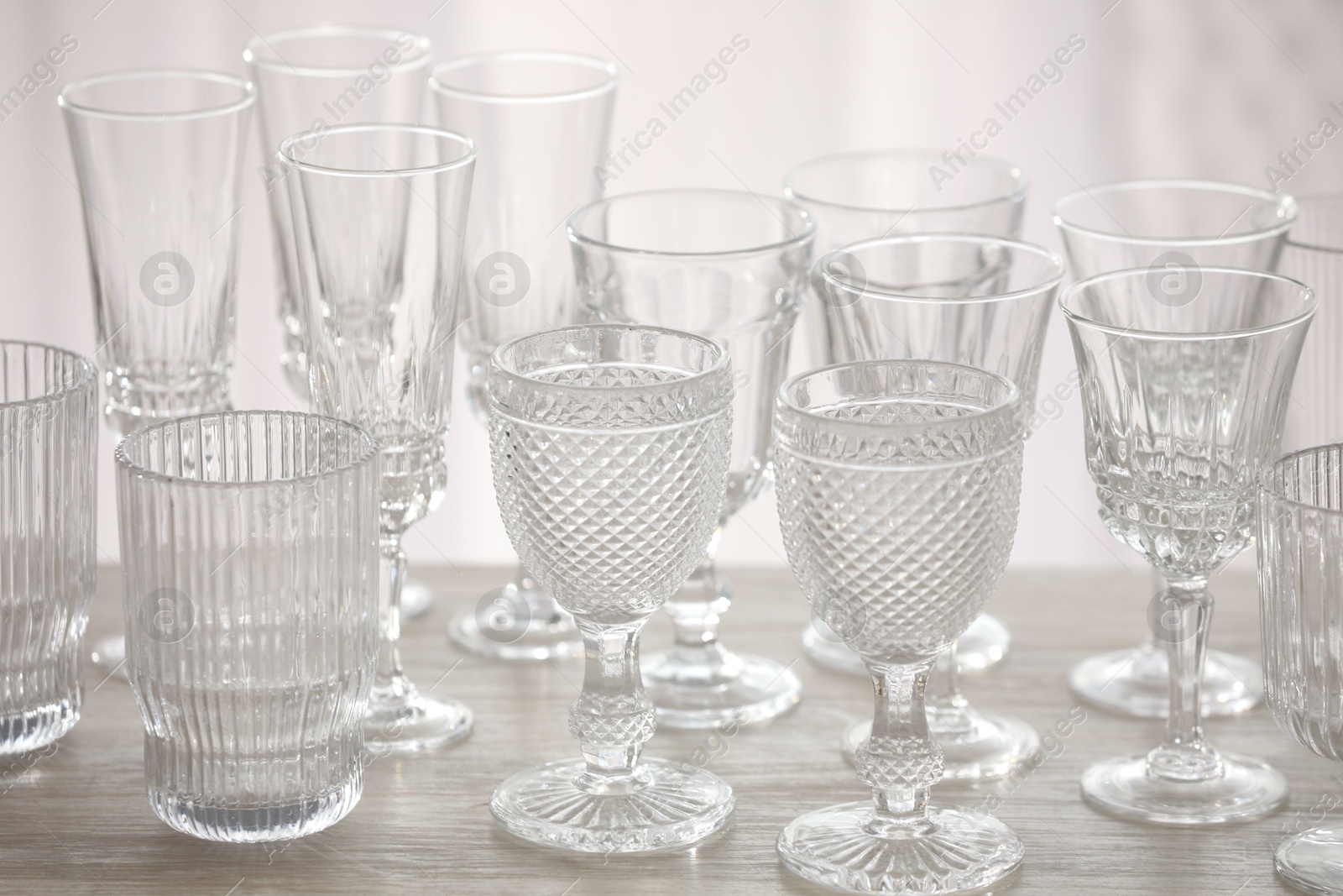 Photo of Empty clean glasses on wooden table indoors, closeup