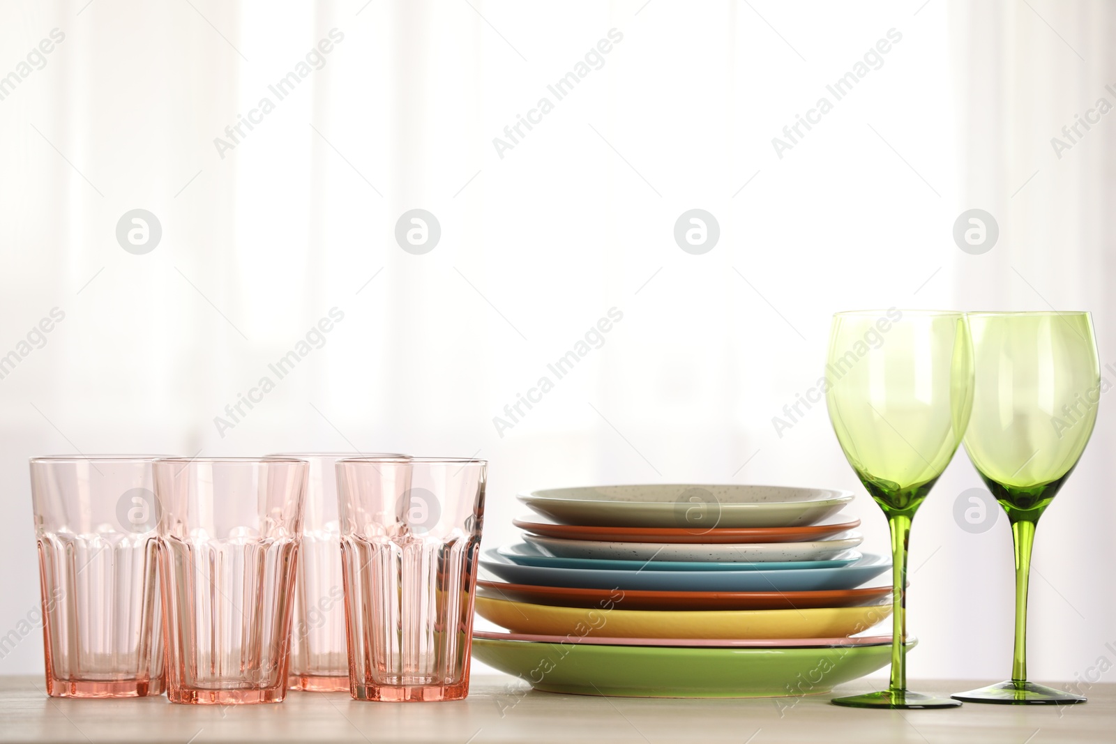 Photo of Empty clean glasses and plates on table indoors