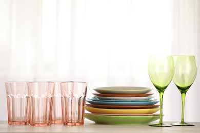 Photo of Empty clean glasses and plates on table indoors