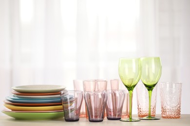 Photo of Empty clean glasses and plates on table indoors