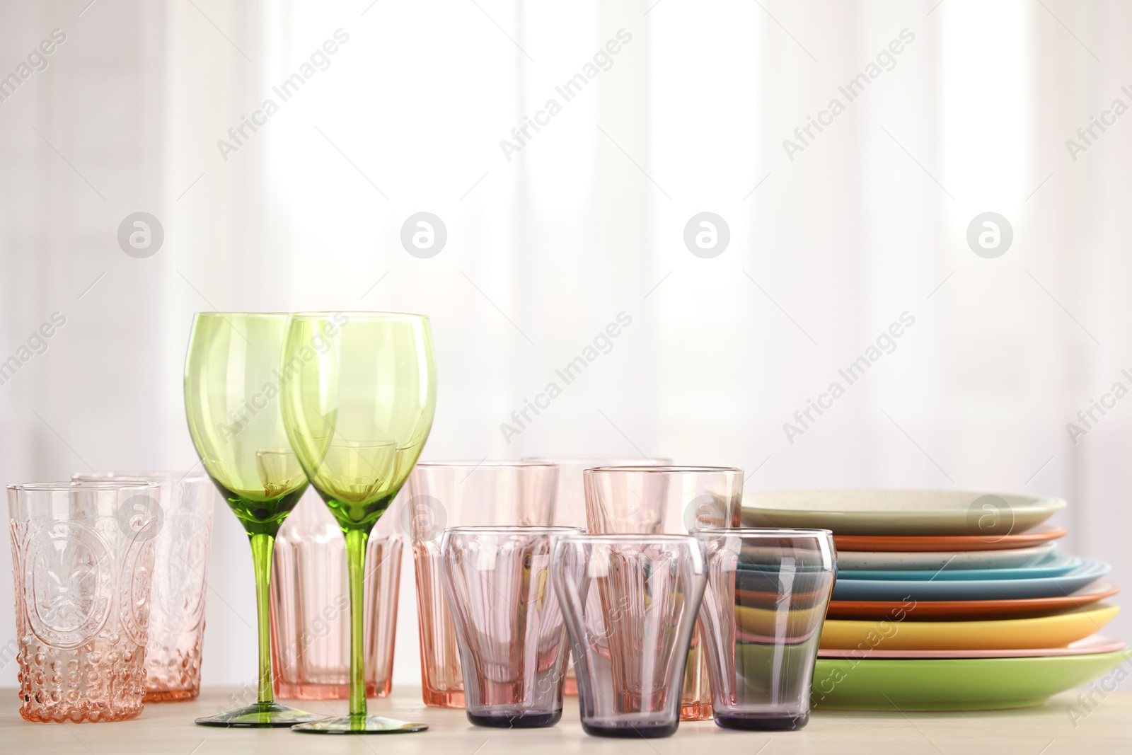 Photo of Empty clean glasses and plates on table indoors