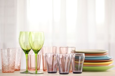 Photo of Empty clean glasses and plates on table indoors