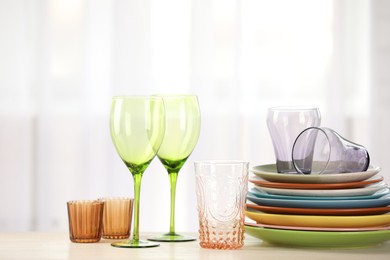 Photo of Empty clean glasses and plates on table indoors