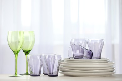 Photo of Empty clean glasses and plates on table indoors