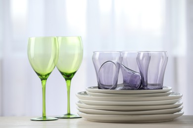 Photo of Empty clean glasses and plates on table indoors