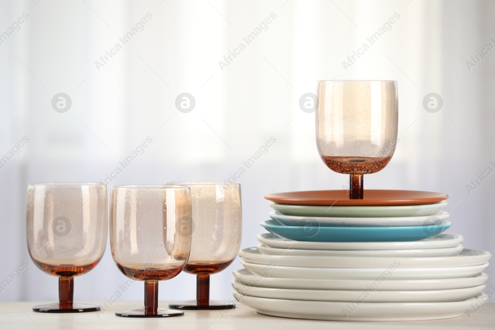 Photo of Empty clean glasses and plates on table indoors