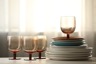 Photo of Empty clean glasses and plates on table indoors