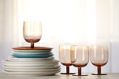 Photo of Empty clean glasses and plates on table indoors