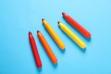 Photo of Many colorful markers on light blue background, flat lay