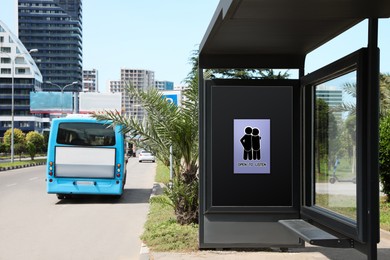 Image of Place where you can receive or give emotional support. Sign with human figures and text Open To Listen on advertising board at public transport stop outdoors