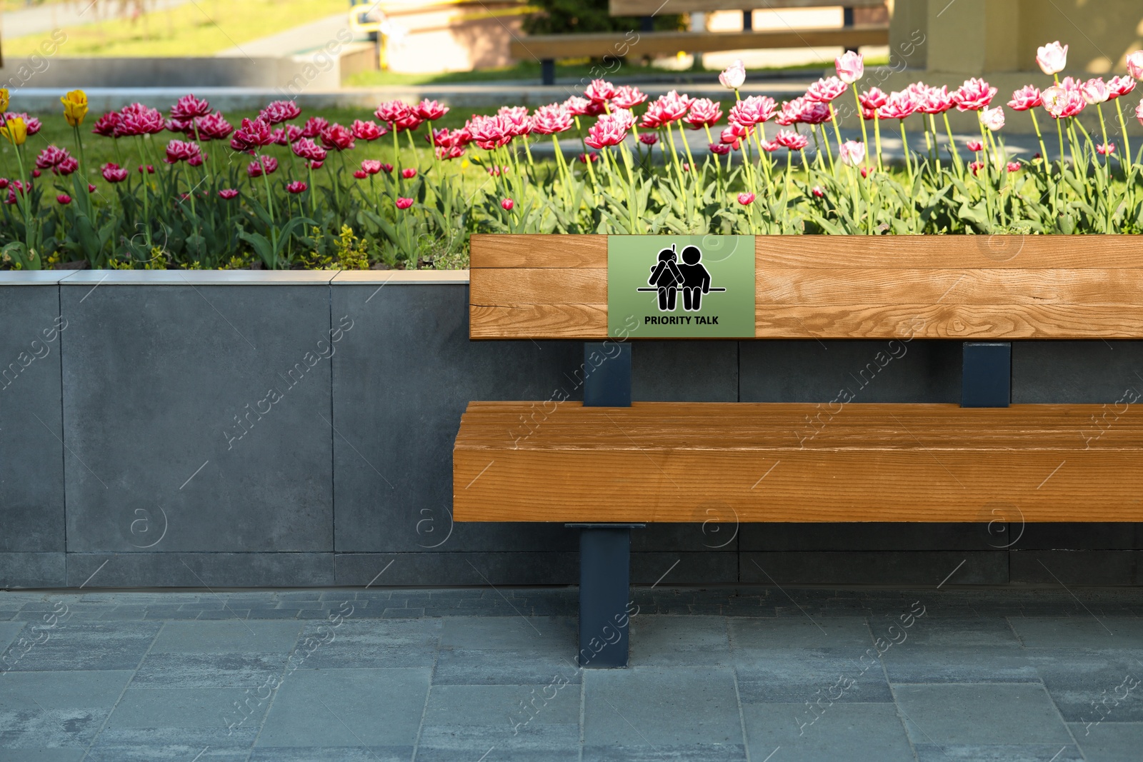 Image of Place where you can receive or give emotional support. Sign with human figures and text Priority Talk on bench outdoors