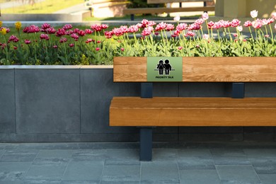 Image of Place where you can receive or give emotional support. Sign with human figures and text Priority Talk on bench outdoors