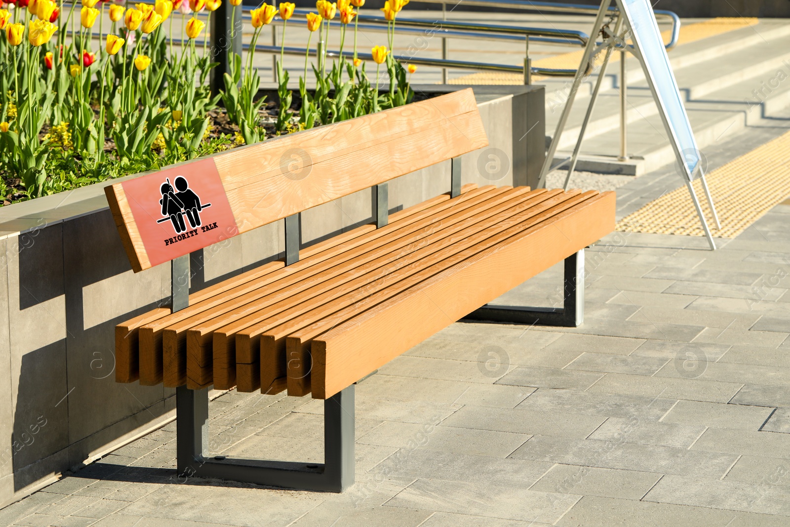 Image of Place where you can receive or give emotional support. Sign with human figures and text Priority Talk on bench outdoors