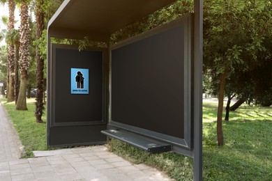 Image of Place where you can receive or give emotional support. Sign with human figures and text Open To Listen on advertising board at public transport stop outdoors