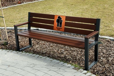 Image of Place where you can receive or give emotional support. Sign with human figures and text Priority Talk on bench outdoors