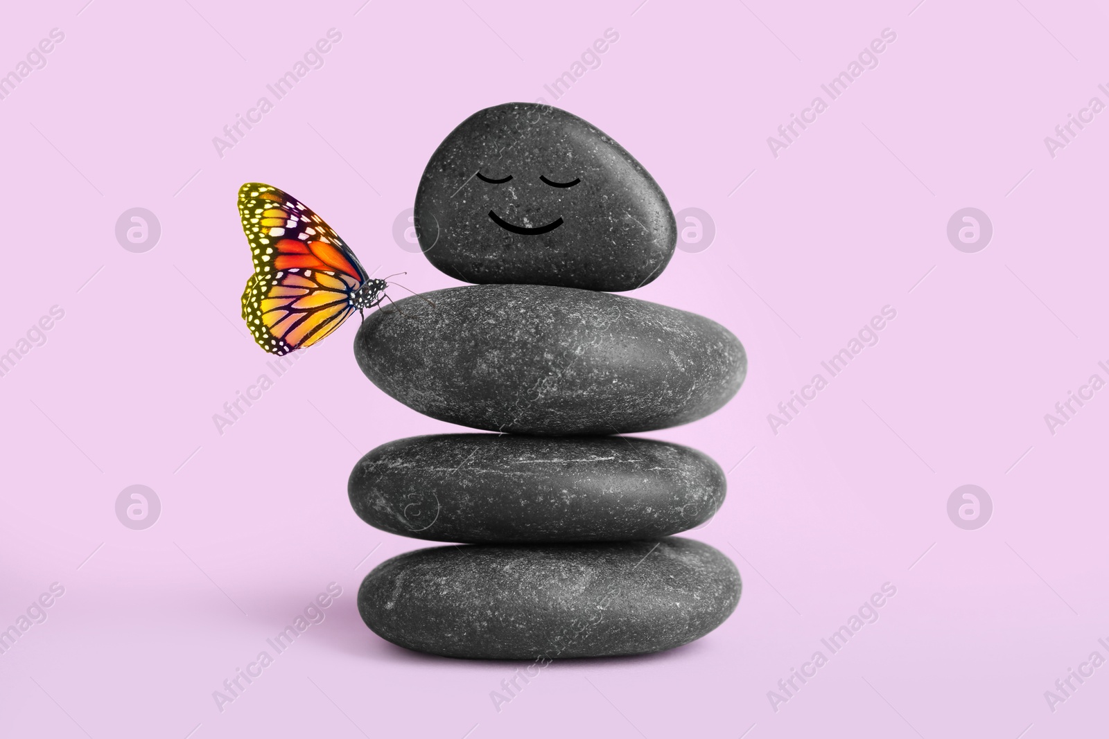 Image of Happy stone glad to see butterfly, harmony. Stacked pebbles and one with smiling face on top against light violet background