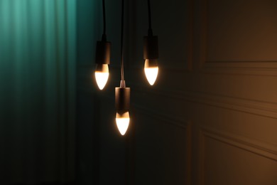 Photo of Glowing light bulbs hanging near wall indoors