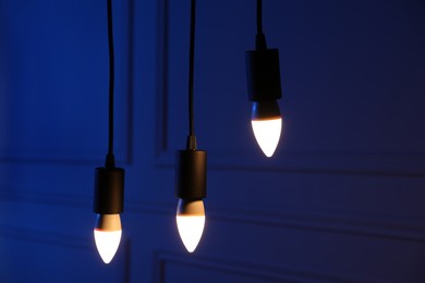 Photo of Glowing light bulbs hanging near wall indoors