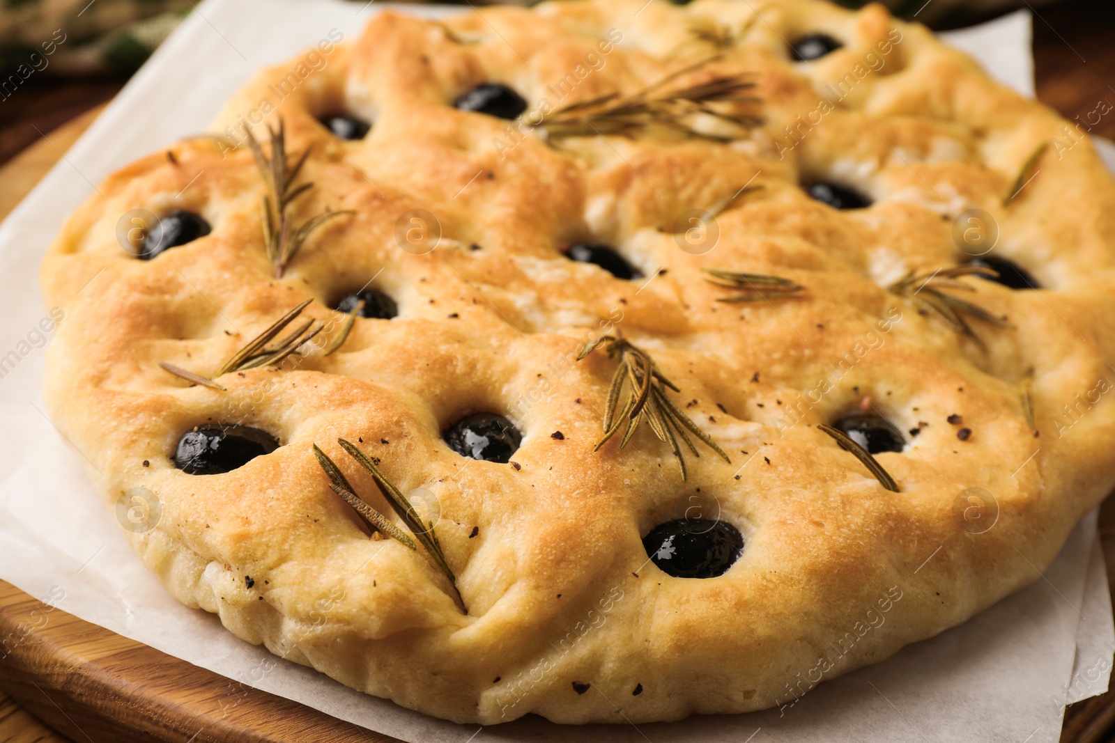 Delicious focaccia bread with olives and rosemary on table, closeup Photo of Delicious focaccia bread with olives and rosemary on table, closeup