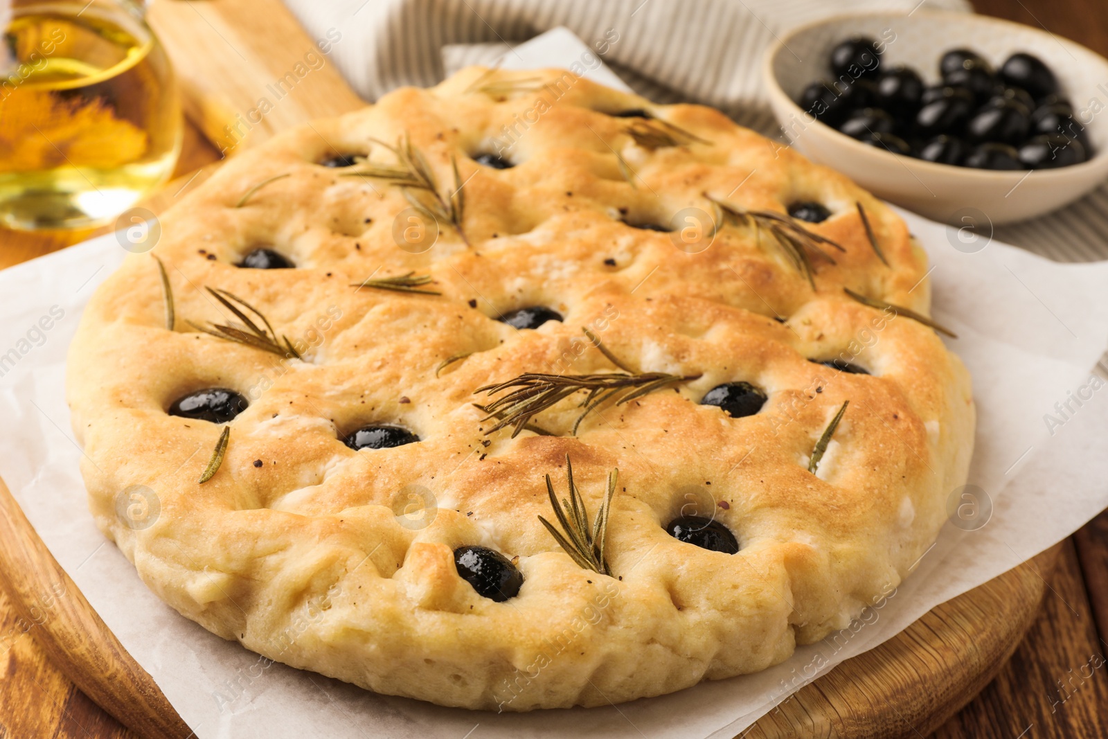 Delicious focaccia bread with olives and rosemary on table, closeup Photo of Delicious focaccia bread with olives and rosemary on table, closeup