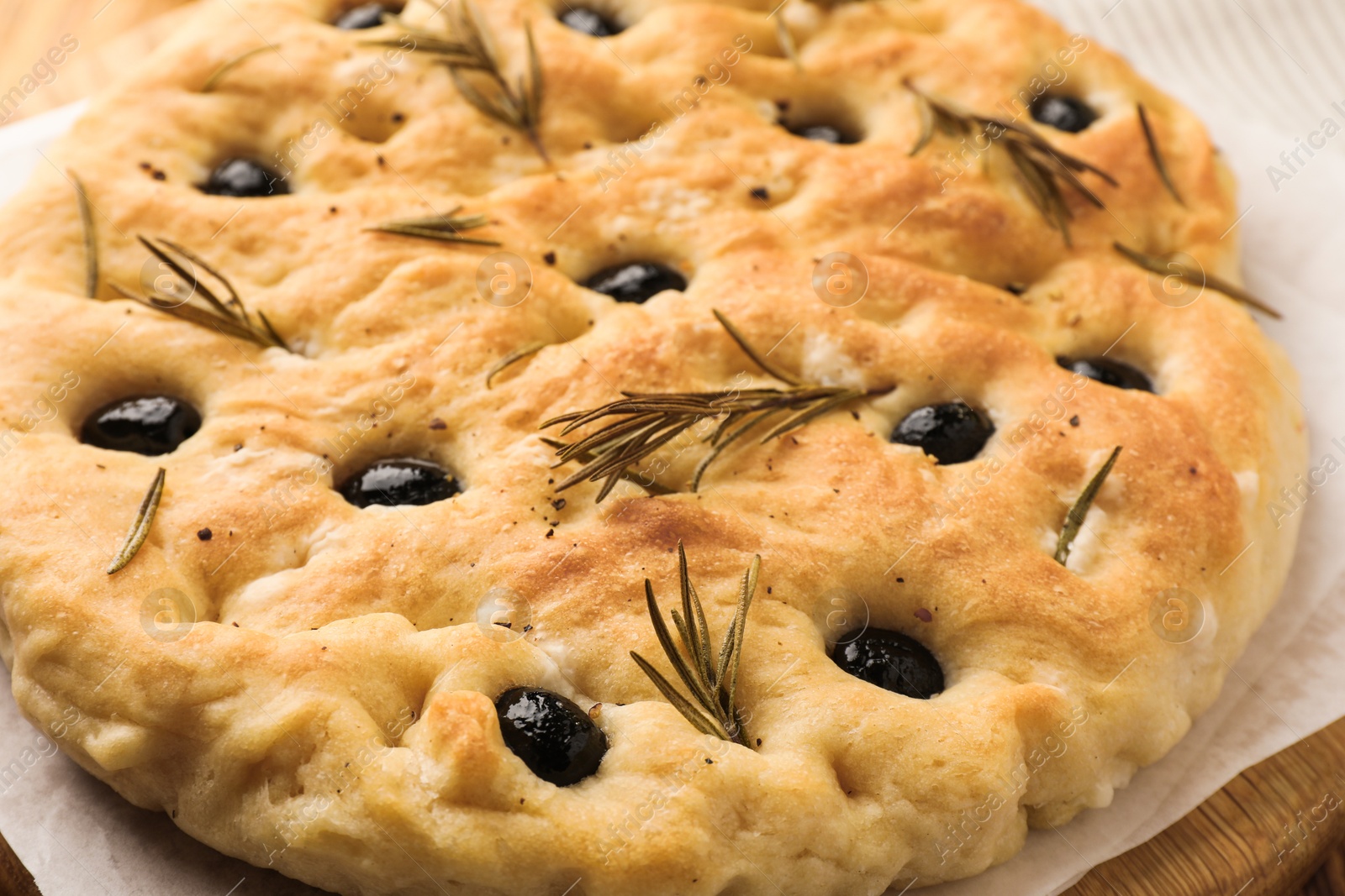 Delicious focaccia bread with olives and rosemary on table, closeup Photo of Delicious focaccia bread with olives and rosemary on table, closeup