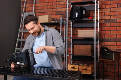 Photo of Relaxing hobby. Man repairing mechanical kitchen scale in workshop