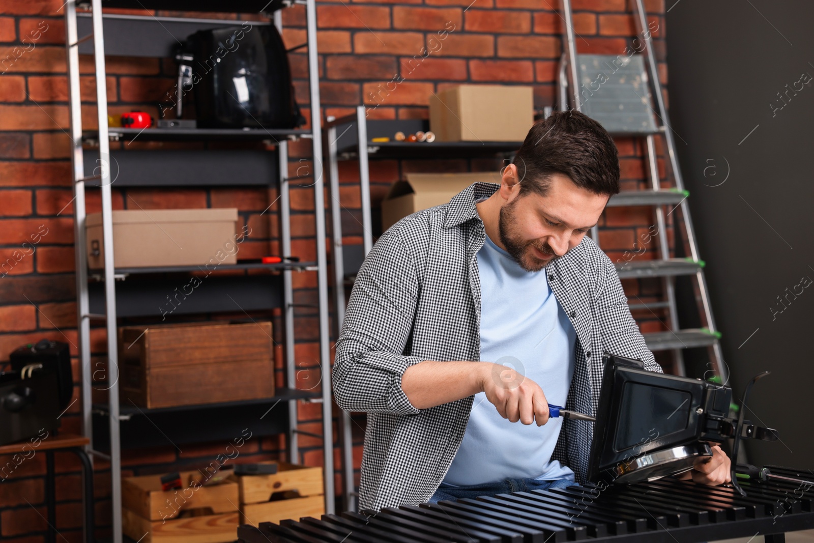 Photo of Relaxing hobby. Man repairing mechanical kitchen scale in workshop