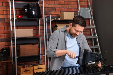 Photo of Relaxing hobby. Man repairing mechanical kitchen scale in workshop