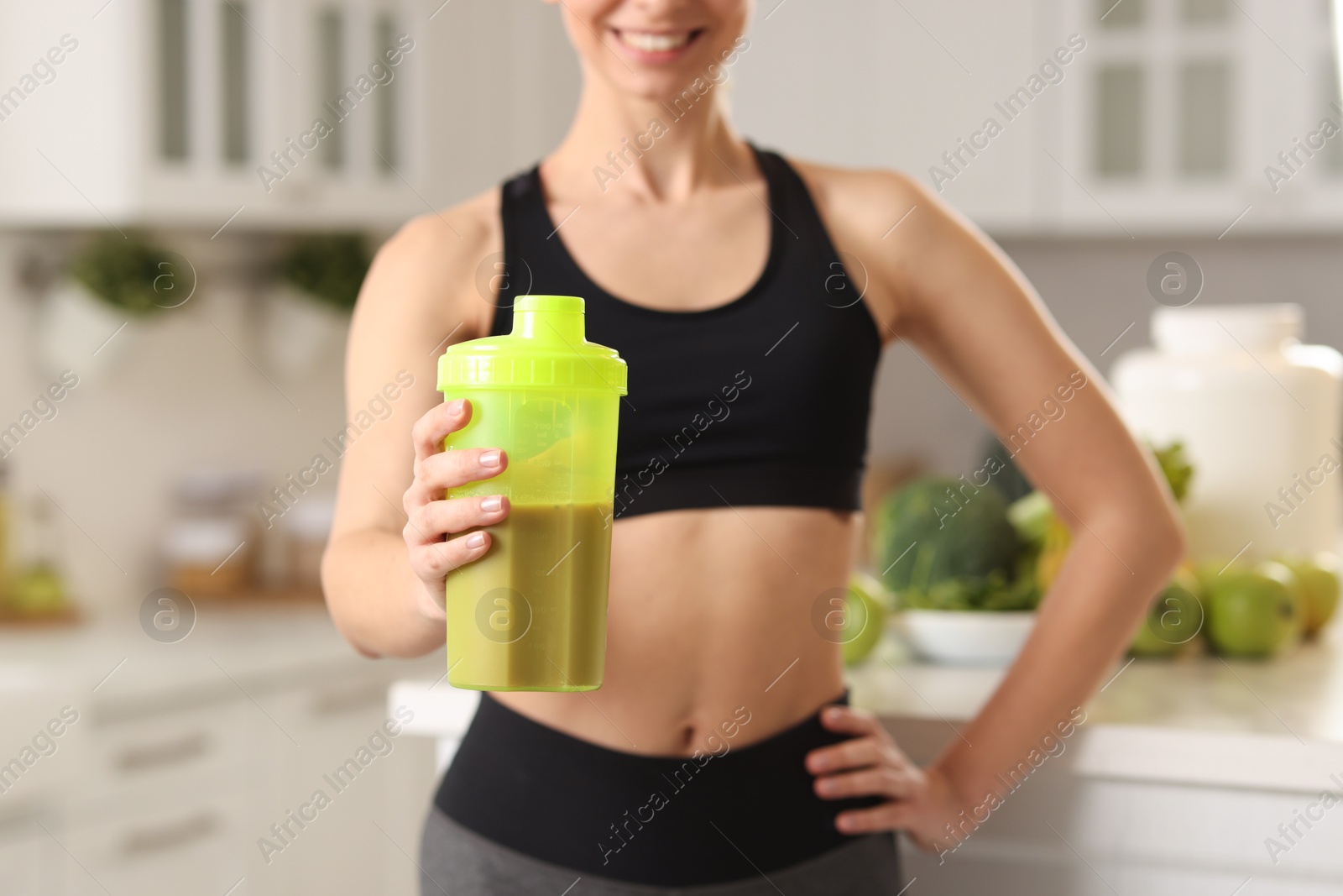 Photo of Weight loss. Woman with shaker of protein in kitchen, closeup