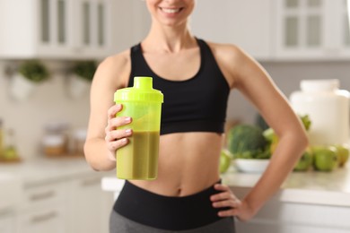 Photo of Weight loss. Woman with shaker of protein in kitchen, closeup