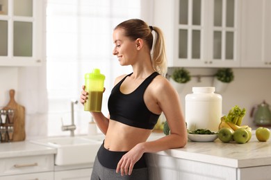 Photo of Weight loss. Happy woman with shaker of protein in kitchen