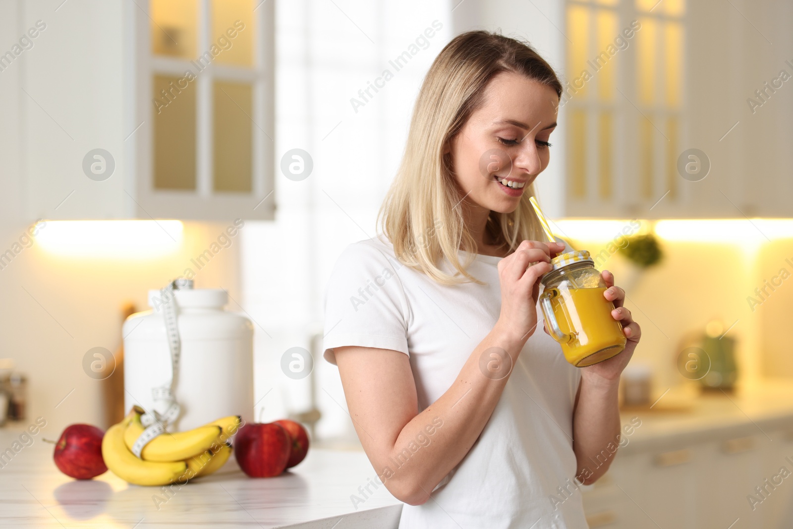 Photo of Weight loss. Woman with tasty shake in kitchen