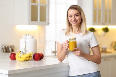 Photo of Weight loss. Woman with tasty shake near white marble table in kitchen