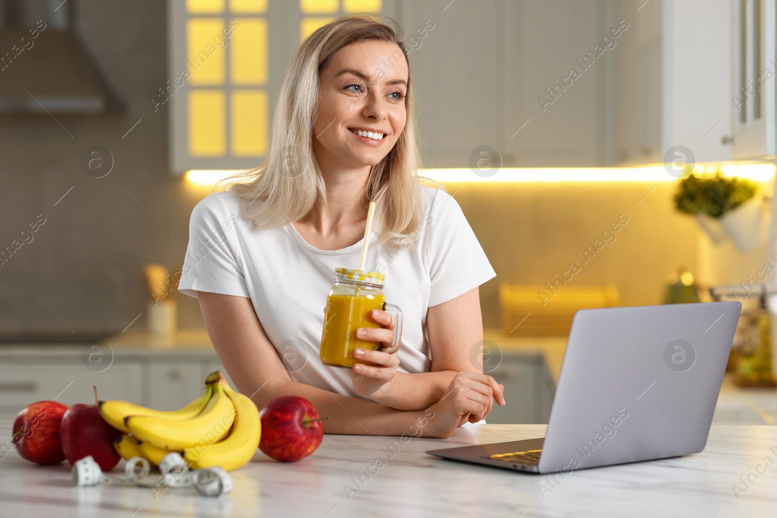 Photo of Weight loss. Happy woman with tasty shake at white marble table in kitchen