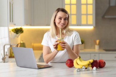 Photo of Weight loss. Happy woman with tasty shake at white marble table in kitchen