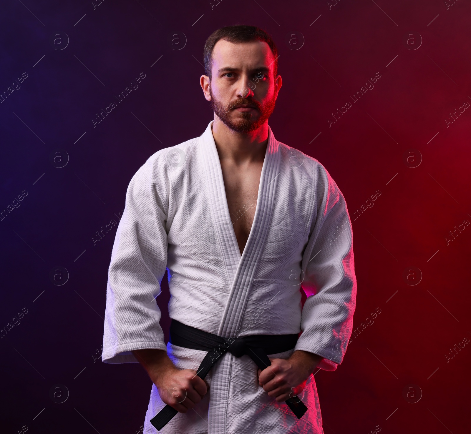 Photo of Karate fighter wearing uniform in color lights