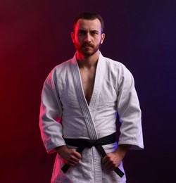 Photo of Karate fighter wearing uniform in color lights