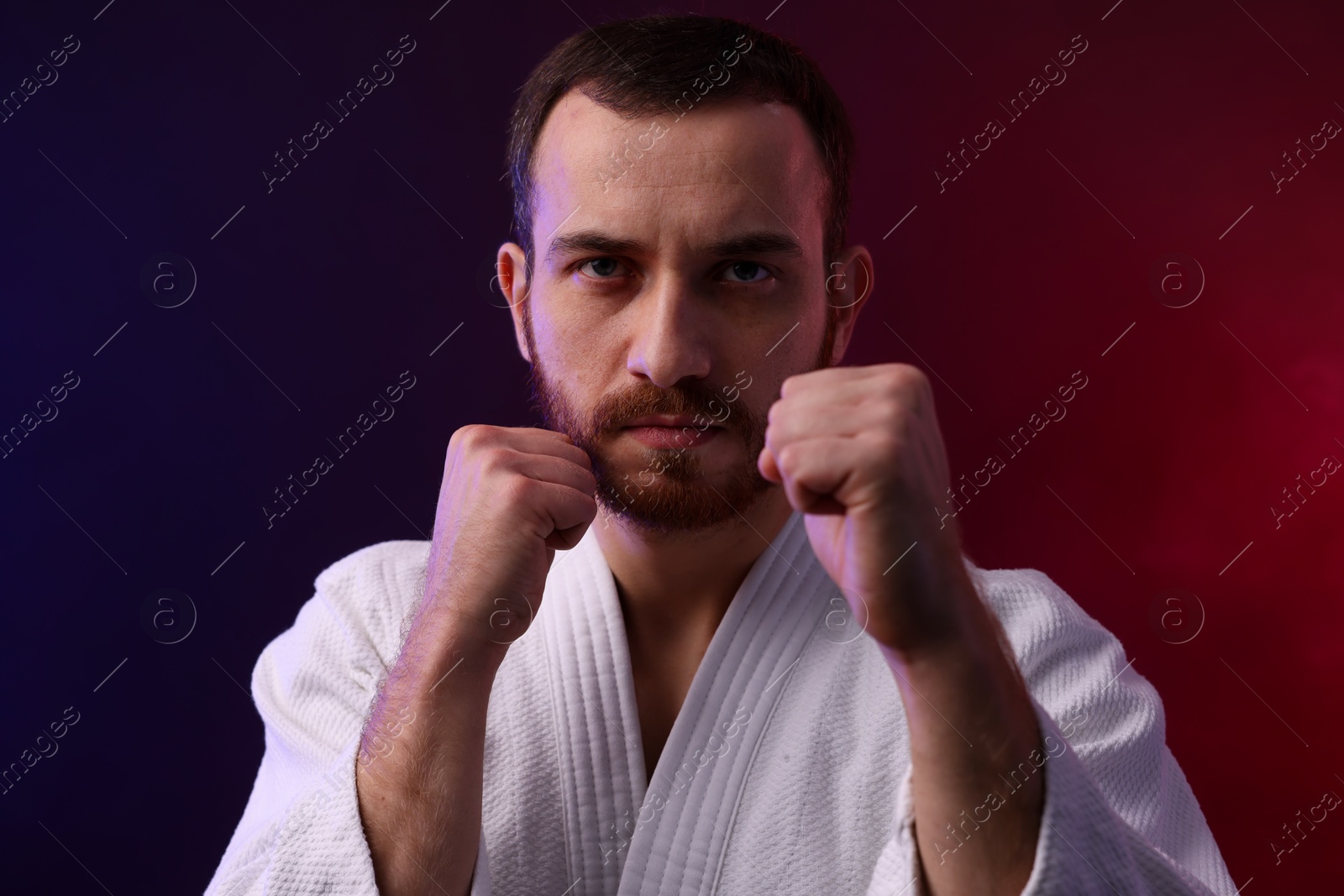 Photo of Karate fighter wearing uniform in color lights