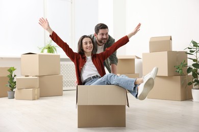 Photo of Moving day. Happy couple having fun in their new home