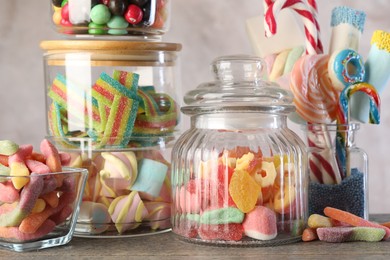 Candy bar. Many different sweets on wooden table against grey background, closeup